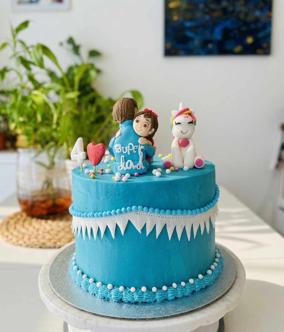 Blaue „Super Dad“-Torte mit Fondant-Figuren und Einhorn.
